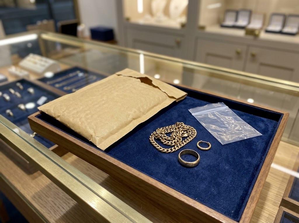 A small padded parcel addressed to the shop, beside gold jewellery ready to be packed.